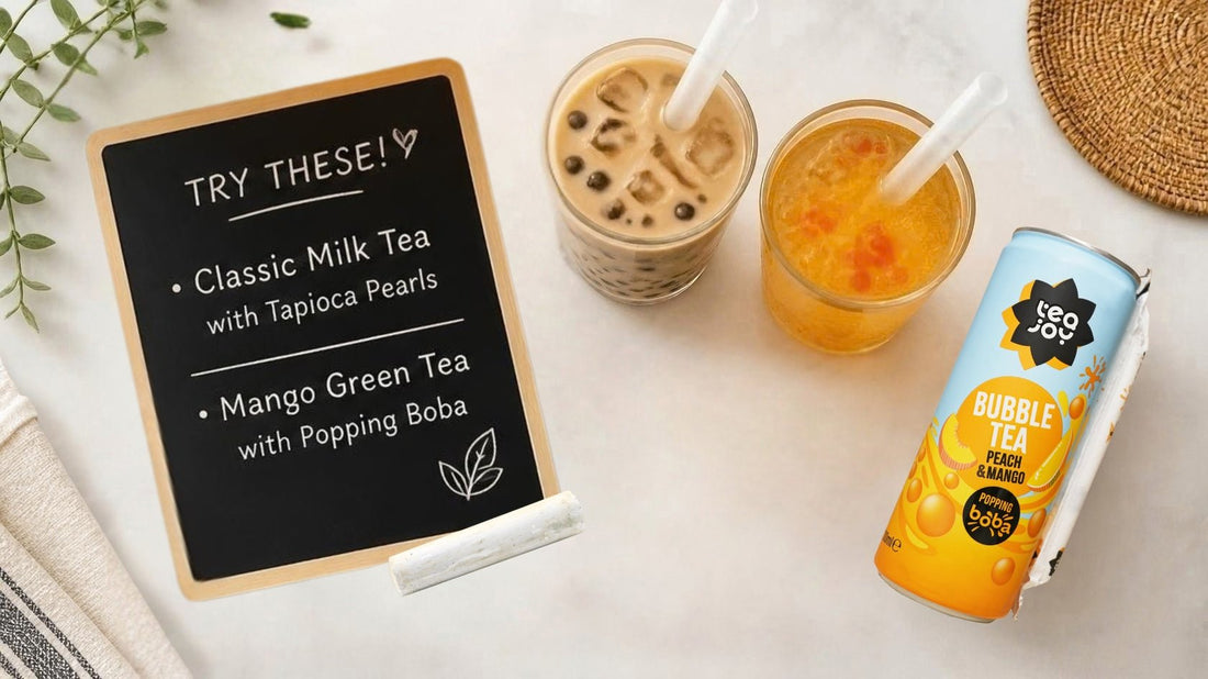 A chalkboard menu of Classic Milk Tea with Tapioca Pearls and Mango Green Tea with Popping Boba, beside both drinks and a TeaJoy Peach & Mango can